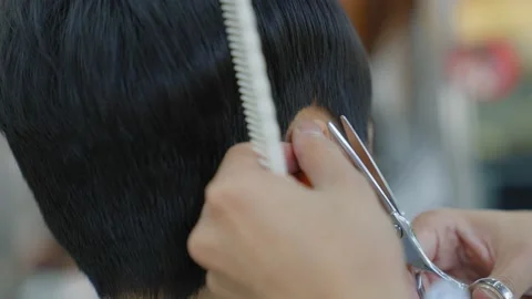 The barber was using scissors to cut the hair around the ear.Professional hai Stock Footage 153953596