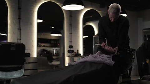 Barber washes the head of a male client in a hair washer. High quality 4k footag Stock Footage 250333788