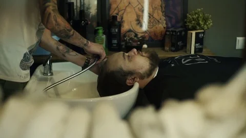 Barber washing man head in barbershop Video stock 69761453