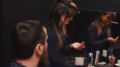 Barber wipes the skin of the client after shaving with cologne Stock Footage 86993335