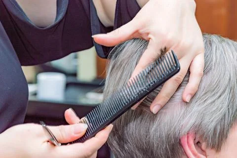 Barber working with scissors, gray-haired woman. hairdresser cutting her hair Stock Photos