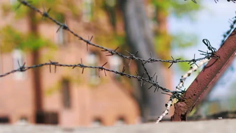 Barberd wire in fronty of prison building in 4k slow motion Vídeos de archivo 94106947