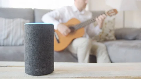 BARCELONA - June 2019: Amazon Echo Alexa and a man playing the guitar Stock Footage 109606692