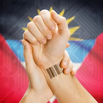 Barcode ID number on wrist and national flag on background - Antigua and B... Stock Photos