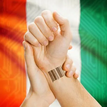 Barcode ID number on wrist and national flag on background - Ivory Coast B... Stock Photos