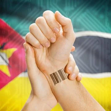 Barcode ID number on wrist and national flag on background - Mozambique Ba... Stock Photos