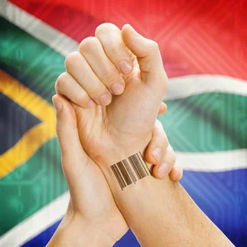 Barcode ID number on wrist and national flag on background - South Africa ... Stock Photos