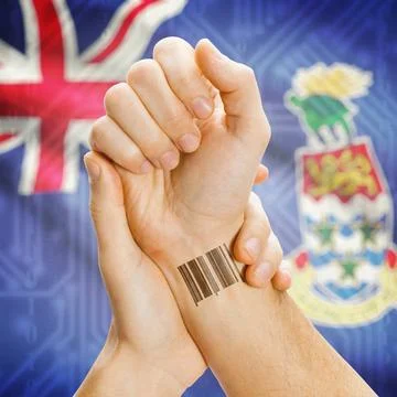Barcode ID number on wrist and national flag on background - Cayman Island... Stock Photos