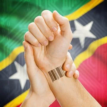 Barcode ID number on wrist and national flag on background - Saint Kitts a... Stock Photos