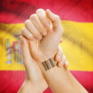 Barcode ID number on wrist and national flag on background - Spain Barcode... Stock Photos