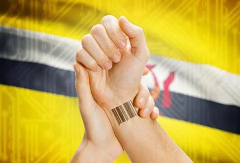 Barcode ID number on wrist of a human and national flag on background - Brune 스톡 사진