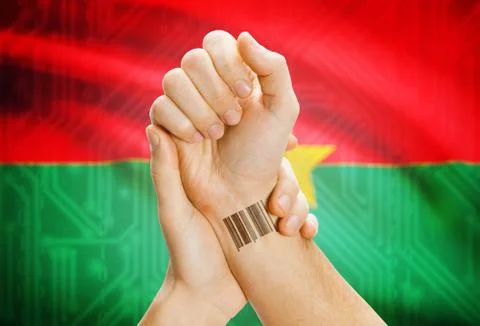 Barcode ID number on wrist of a human and national flag on background - Burki Stockfoto's
