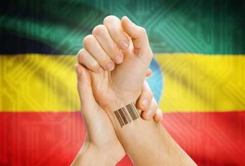 Barcode ID number on wrist of a human and national flag on background - Ethio 写真素材