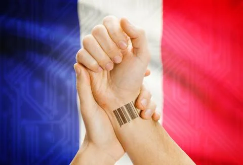 Barcode ID number on wrist of a human and national flag on background - Franc 写真素材