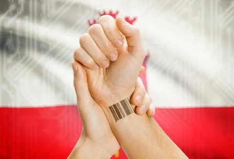 Barcode ID number on wrist of a human and national flag on background - Gibra 스톡 사진