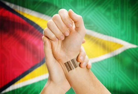 Barcode ID number on wrist of a human and national flag on background - Guyan Stock-Fotos