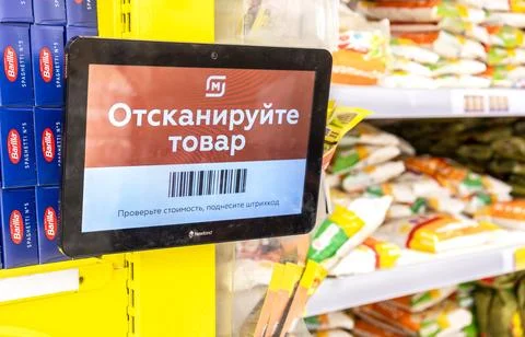 Barcode scanner on the wall in the chain hypermarket Magnit. Text in Russia.. Stock Photos