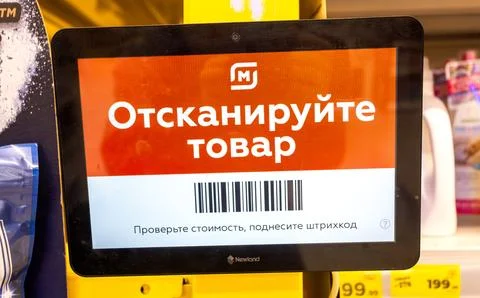 Barcode scanner on the wall in the chain hypermarket Magnit. Text in Russia.. Stock Photos