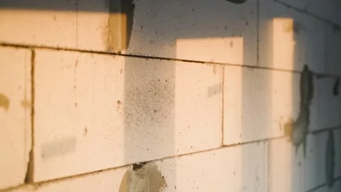 Bare aerated concrete wall with warm sunset rays of the setting sun. Shadow from Stock Footage 230766080