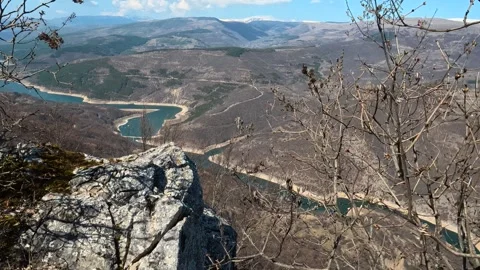 Bare branches frame a rocky cliff's edge. Balkan, Eastern Europe, POV Video stock 331813958