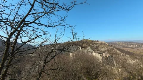 Bare branches frame a vast, sunlit hillside. Mount Ozren Vidéo 330959911