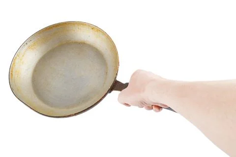 Bare caucasian hand holding empty old aluminium frying pan Stockfoto's