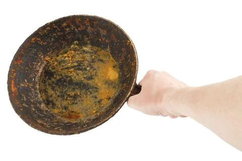 Bare caucasian hand holding empty old cast iron frying pan Stockfoto's