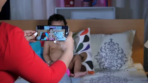A bare-chested cute toddler posing for the camera while sitting on the bed Stock Footage 161053691