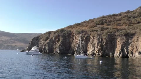 Bare cliff and moored yachts bathed in the late sun Video stock 68004648