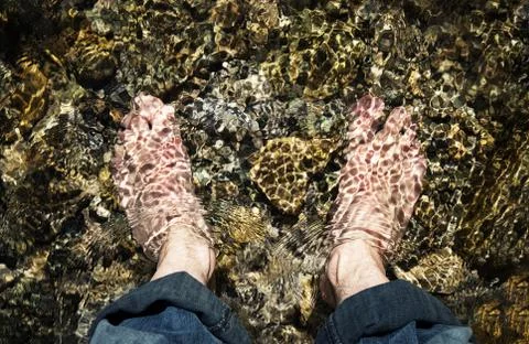 Bare feet in a cold mountain stream Stock Photos