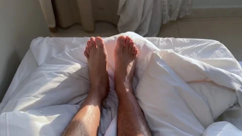 Bare Feet Resting On Sunny White Bed Sheets Stock Footage 345475066