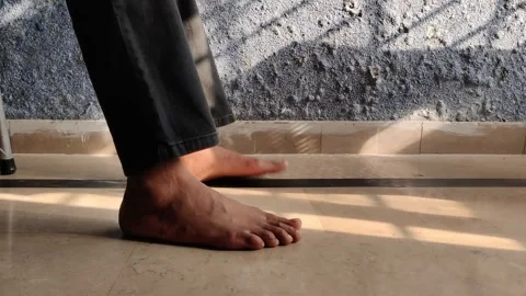 Bare Feet of Seated Man Tap Floor in Repetitive Rhythm Facing Fungus Wall Video stock 312932728