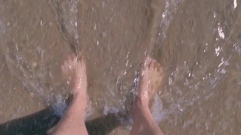 Bare feet on the shore of the beach when the wave recedes Stock Footage 124375676