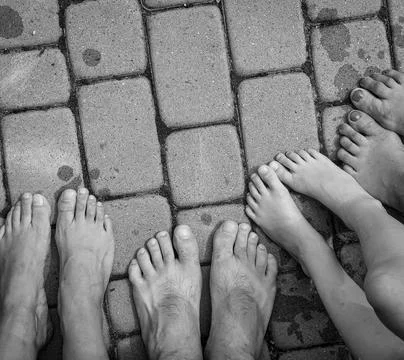 Bare feet on the sidewalk Stock Photos