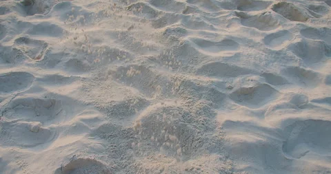 A bare foot kicks up a spray of fine white sand, leaving a dynamic pattern on a  Stock Footage 262454027