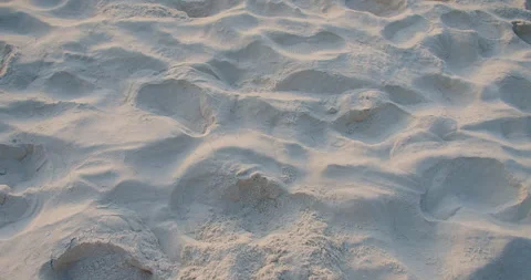A bare foot kicks up a spray of fine white sand, leaving a dynamic pattern on a  Stock Footage 262454683