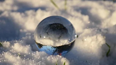 Bare Hand Gently Spins Crystal Ball Resting in Snow in Slow Motion Stock Footage 300825250