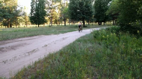 Bare man rides a bike on a forest road Video stock 114635751