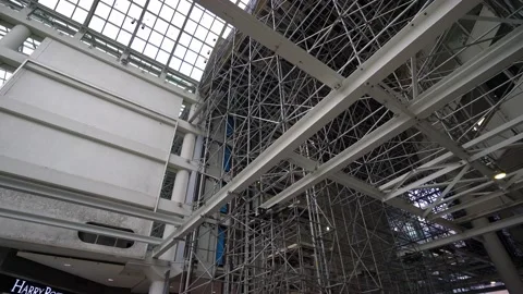 Bare scaffolding envelopes white structural steel girders during Stock Footage 180544012