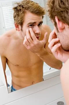 Barechested man in front of bathroom mirror Stock Photos