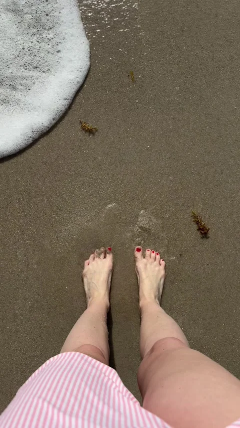 Barefoot beach walk: waves gently washing over sandy shore as steps embrace.. Video stock 315524708