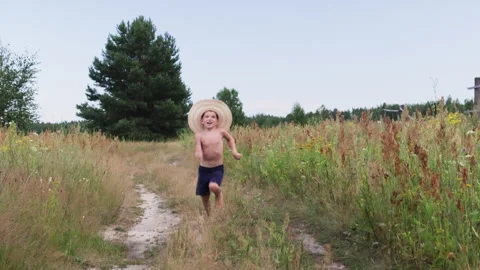 Barefoot boy in hat running to camera. Stock Footage 287327731