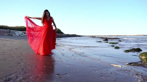 Barefoot brunette in red dress walks alo... | Stock Video | Pond5