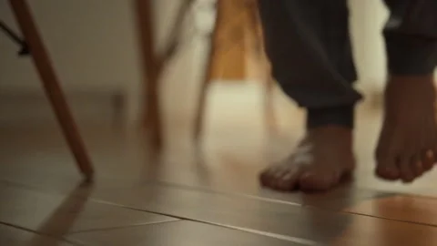 Barefoot exploration in a calm indoor setting during afternoon light Stock Footage 323730548