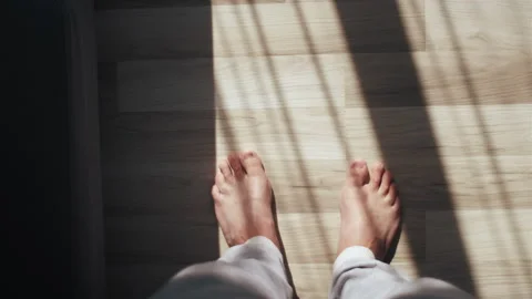 Barefoot guy standing indoors inside at home enjoy warm wooden heated floor Stock Footage 248764114
