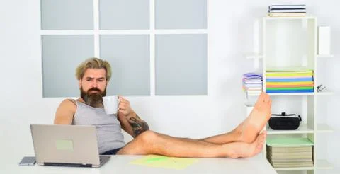 Barefoot guy working from home. Developer work computer. Social networks 스톡 사진