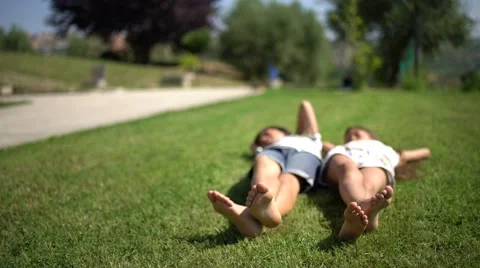 Barefoot little boy and girl lying on th... | Stock Video