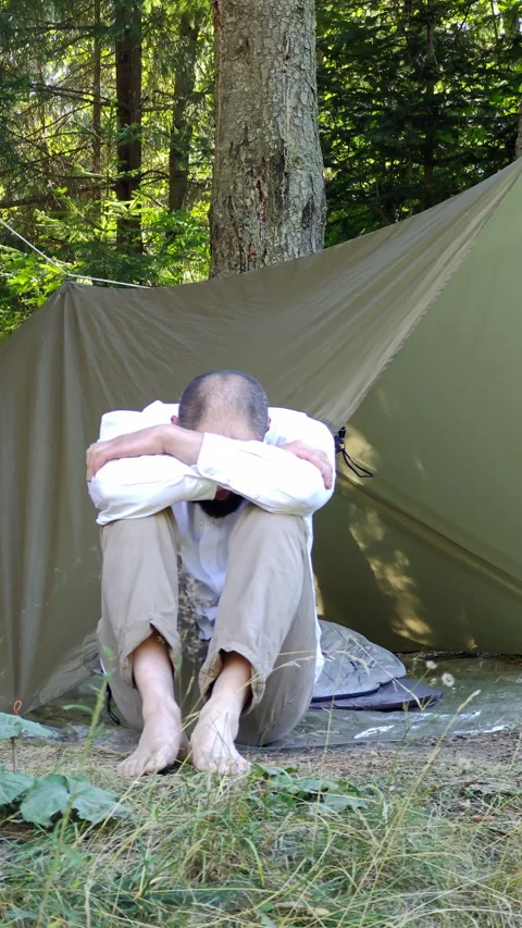 Barefoot Man Sitting by Camping Tarp Shelter in Summer Forest Stock Footage 345065606