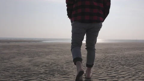 Barefoot man walking on the beach in winter time Stock Footage 233985019