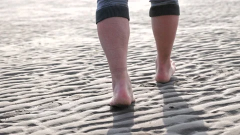 Barefoot man walking on sand beach Stock Footage 233982491